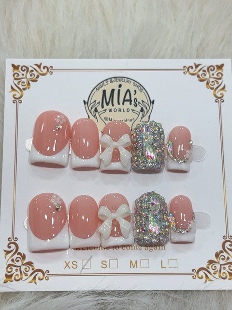 Handmade short square peach blush French tip press-on nails with bow and rhinestone details