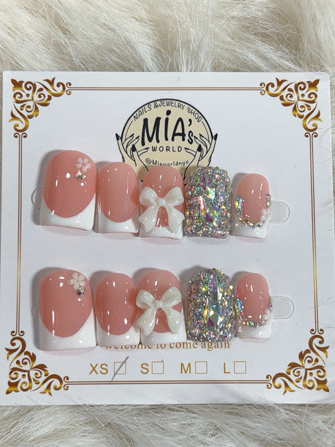 Peach blush coquette French press-on nails with white bow and crystal accent nail